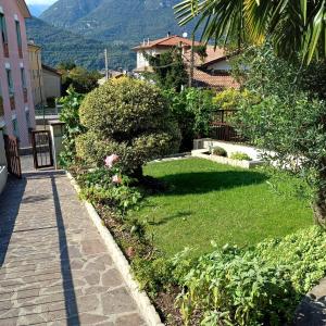 a garden with a walkway next to a building at Casa Giulia, Darfo Boario Terme Ospitar in Darfo