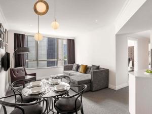 a living room with a table and a couch at Mantra 2 Bond Street in Sydney