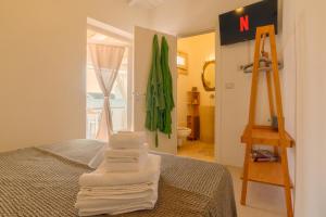 a room with a bed and a ladder and towels at CAMASUD 3 L'ATTICO Nardò in Nardò