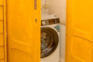 a washing machine in a room with a yellow door at CAMASUD 3 L'ATTICO Nardò in Nardò