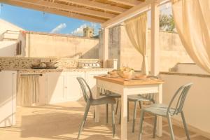 a kitchen with a table and chairs and a table at CAMASUD 3 L'ATTICO Nardò in Nardò