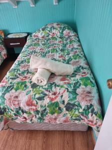 a bed with a towel laying on top of it at Cabañas Jade in Cochamó