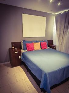a bedroom with a large bed with colorful pillows at 2 BEDROOM Condo -IPANEMA in Rio de Janeiro