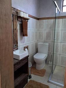 a bathroom with a toilet and a sink and a shower at Casa Aconchego in São Gabriel