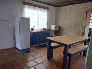 a kitchen with a wooden table and a refrigerator at Casa Aconchego in São Gabriel