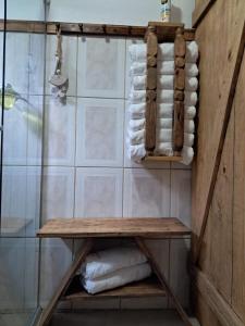 a bathroom with a wooden shelf and towels at Casa Aconchego in São Gabriel