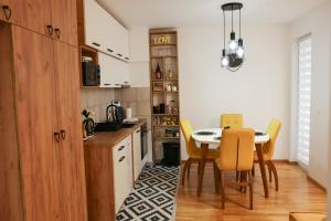 a kitchen with a dining room table and yellow chairs at Apartman Wish Lux in Vrnjci
