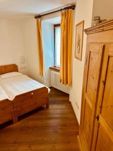 a bedroom with a bed and a window with yellow curtains at Agritur Ca' de Mel in Fiavè