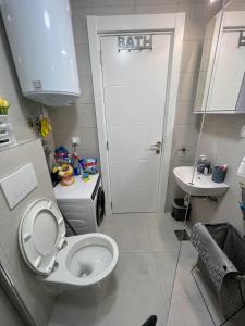 a bathroom with a white toilet and a sink at Apartman Wish Lux in Vrnjci +26 photos