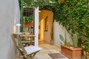 a patio with a chair and a table with plants at CAMASUD 3 L'ATTICO Nardò in Nardò