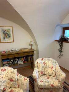 a living room with a chair and a book shelf at Agritur Ca' de Mel in Fiavè