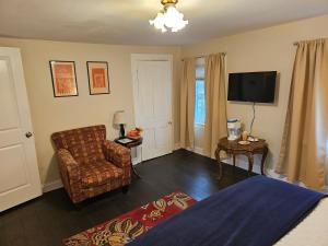 a living room with a chair and a television at Come As You Are Inn LLC in Sayville