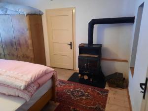 a stove in a room with a bed and a door at Chalupa u Josefa in Valašská Polanka