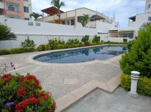 a swimming pool in a yard next to a building at Apartamento playa Tonsupa in Tonsupa