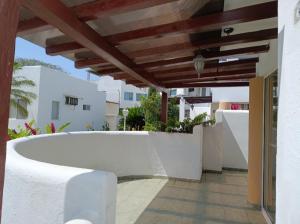 an outdoor patio with a wooden pergola at Apartamento playa Tonsupa in Tonsupa