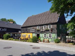 a green building with a black roof on a street at Gohrischer Hof Anno 1798 in Kurort Gohrisch