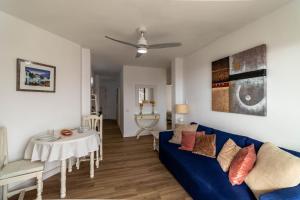 a living room with a blue couch and a table at RentitSpain - Nerja - Apartamentos Vistas Únicas al Mar Mediterráneo in Nerja