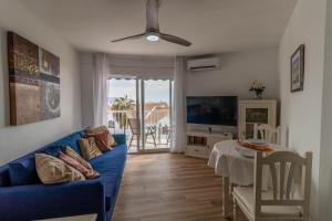a living room with a blue couch and a table at RentitSpain - Nerja - Apartamentos Vistas Únicas al Mar Mediterráneo in Nerja