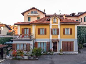 a large yellow house with brown shutters at Dimora Marisa in Albiate