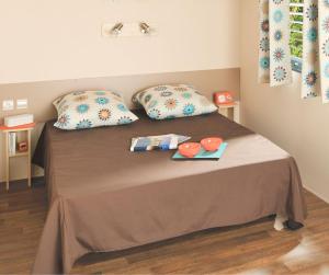 a bed with two pillows and two plates on it at Camping Amélia in Amélie-les-Bains-Palalda +14 photos