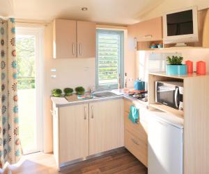 a small kitchen with a sink and a microwave at Camping Amélia in Amélie-les-Bains-Palalda