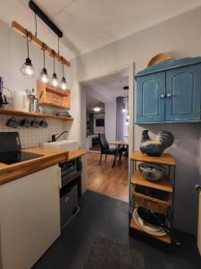 a kitchen with blue cabinets and a dining room at 15 Vogelnest - Hof Wiesengrund in Parchtitz