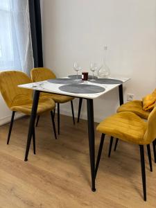 a white table with chairs and wine glasses on it at Museum 4 Residence in Debrecen