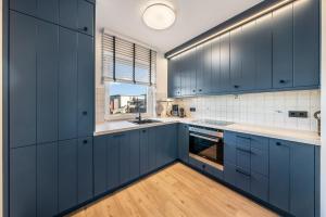 a kitchen with blue cabinets and a window at Mare in Hörnum