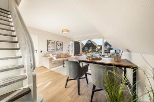 a dining room and living room with a table and chairs at Mare in Hörnum +15 photos