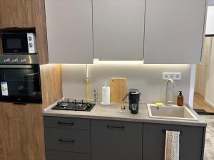 a kitchen with a sink and a stove and a microwave at Museum 4 Residence in Debrecen +4 photos