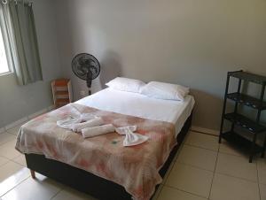 a bedroom with a bed with towels on it at Hospedagem estação in Morretes