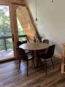 a dining room with a wooden table and chairs at Post Oak Perch-Cozy Forest A-frame Near Bentonville in Rogers