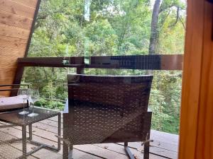 a table and a chair in front of a window at Black Walnut Bungalow-Cozy Forest A-frame near Bentonville in Rogers