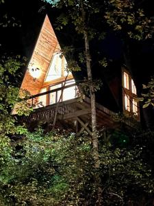 a house with a wooden porch in front of it at Black Walnut Bungalow-Cozy Forest A-frame near Bentonville in Rogers