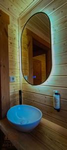a bathroom with a round mirror and a blue sink at Chale do Avô Chico Penhas da Saúde in Penhas da Saúde +74 photos
