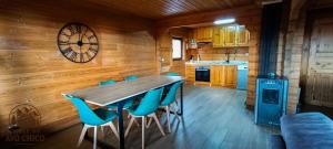 a kitchen with a wooden wall with a table and chairs at Chale do Avô Chico Penhas da Saúde in Penhas da Saúde