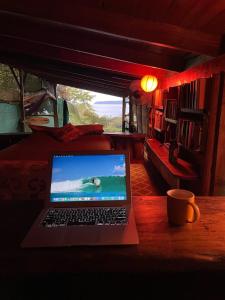 a laptop computer sitting on a table in a room at Open spacious house with stunning Peninsula view in Pavones