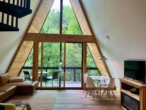 a living room with a large glass window at Running Spring Retreat-Cozy Forest A-Frame near Bentonville in Rogers