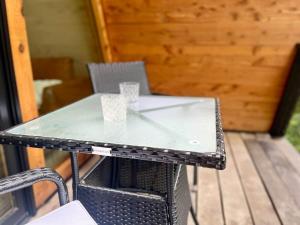 a glass table on a porch with two glasses on it at Running Spring Retreat-Cozy Forest A-Frame near Bentonville in Rogers +22 photos
