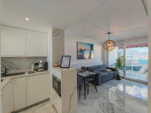 a kitchen and living room with a couch and a table at Sea&Skyline Suites Benidorm in Benidorm