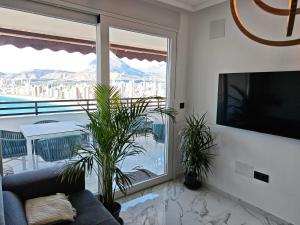 a living room with a couch and a large window at Sea&Skyline Suites Benidorm in Benidorm
