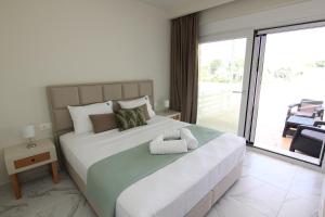 a bedroom with a large bed and a balcony at Holiday Luxury Villas in Kalamaki +102 photos