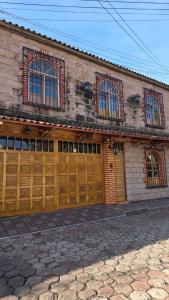 a brick building with wooden garage doors on it at Casa Quijote in Chiautla