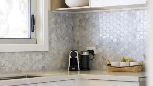 a kitchen counter with a coffeemaker on the counter at Absolute Birubi Beachfront in Anna Bay +34 photos