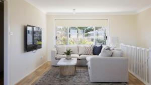 a living room with a couch and a table at Absolute Birubi Beachfront in Anna Bay