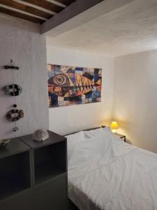 a bedroom with a bed and a painting on the wall at LA GRENILLE in Antibes +19 photos