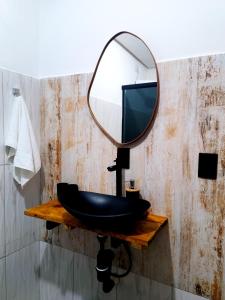 a bathroom with a black sink and a mirror at Tiny House, Refúgio Aconchegante em Mucugê in Mucugê