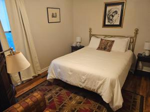 a bedroom with a bed with white sheets and a window at Come As You Are Inn LLC in Sayville +16 photos