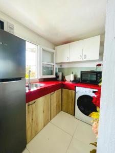 a kitchen with red counter tops and a dishwasher at OASIS Suite in Schœlcher