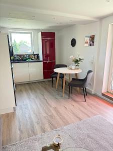 a living room with a table and chairs and a kitchen at Ferienwohnung Haus Grenzwald in Nettetal +4 photos